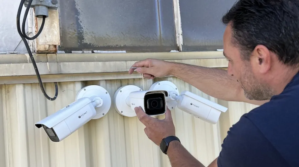Technicien FGS installant une caméra de vidéosurveillance